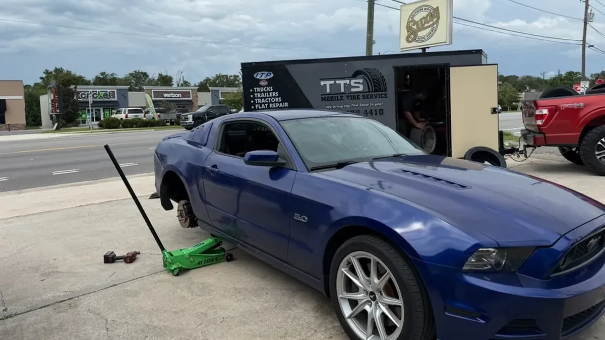 Mustang with its wheel off on the roadside in Ocala, Florida, with the Taylor Mobile Tire Service trailer parked behind it