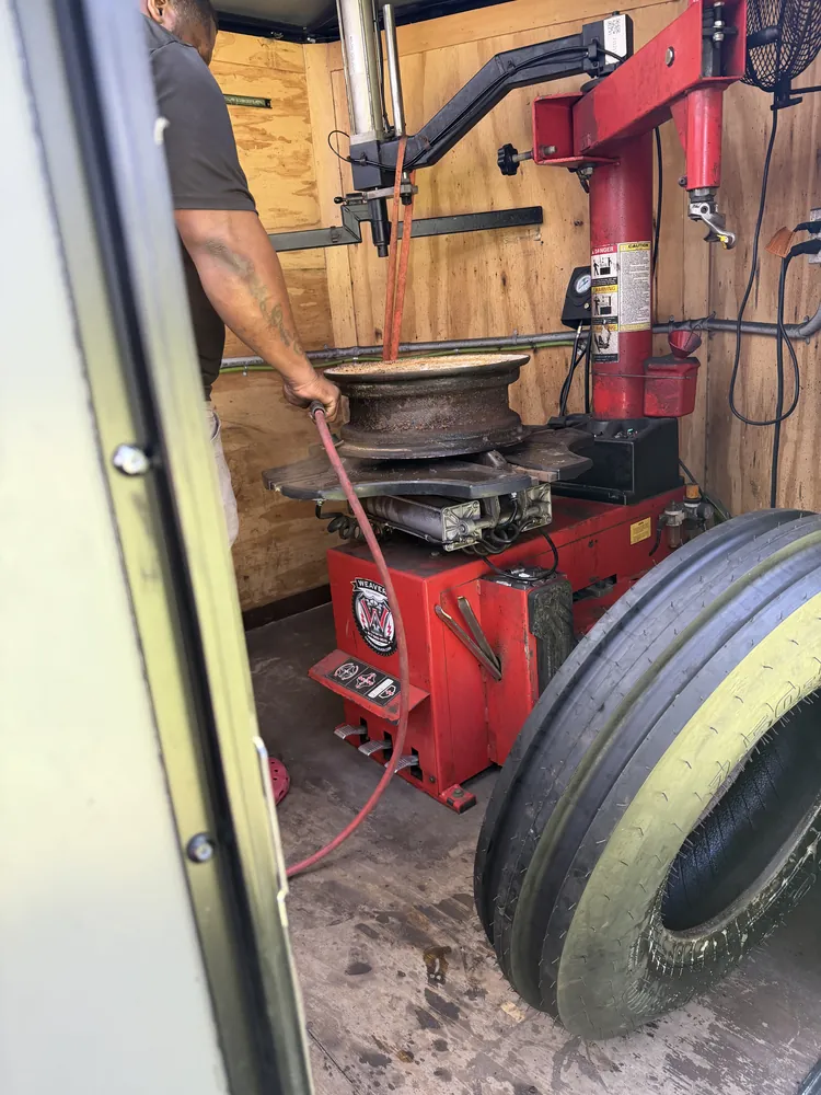 Tractor implement tire being mounted in the mobile tire shop trailer in Marion County